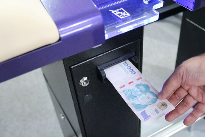 Persona ingresando billetes